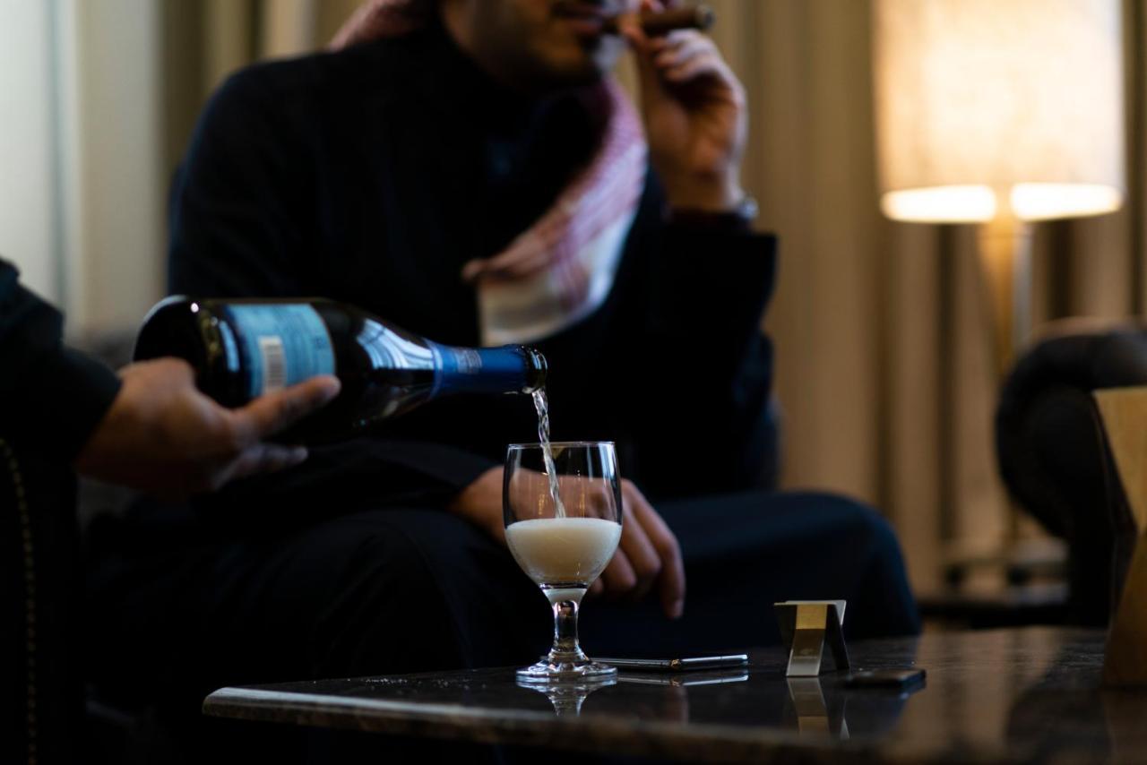 Vittori Palace Hotel And Residences Riyadh Exterior photo A man pouring a glass of champagne